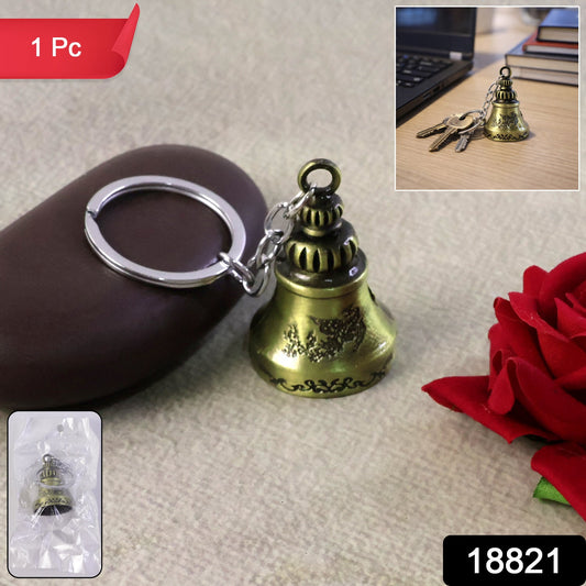 Handcrafted metal temple bell keychain with a subtle ringing feature on a dark background.