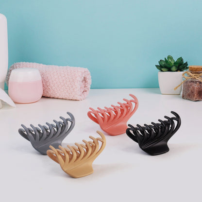 Matte hair claw clip resting on reflective surface