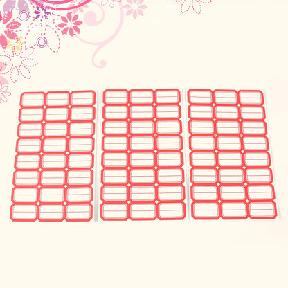 Overhead view of neatly arranged red border label stickers on a surface.