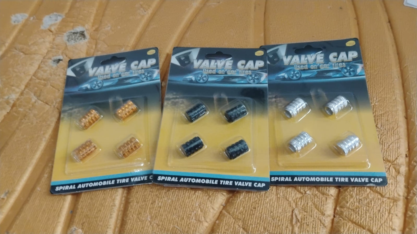 A silver aluminium valve stem cap resting gently on a smooth surface.
