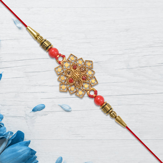 Traditional Golden Floral Rakhi With Intricate Design And Red Beads On Red Thread