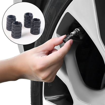 Four silver aluminium tire valve stem caps neatly arranged in a row.